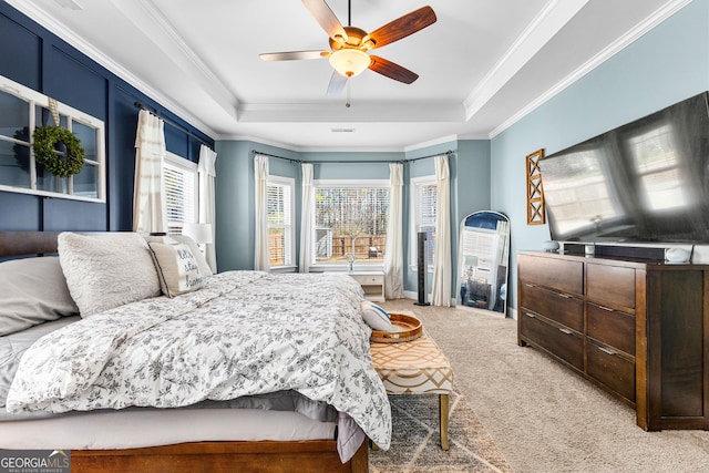 bedroom featuring a raised ceiling, light colored carpet, crown molding, and ceiling fan