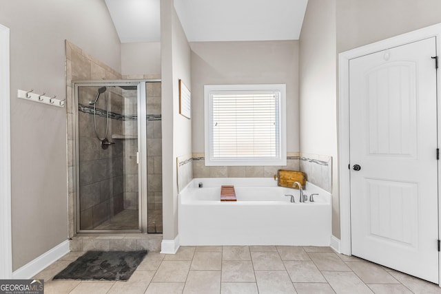 bathroom with a stall shower, tile patterned flooring, and a bath