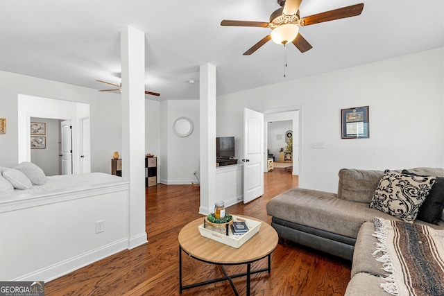 living room featuring a ceiling fan, baseboards, and wood finished floors