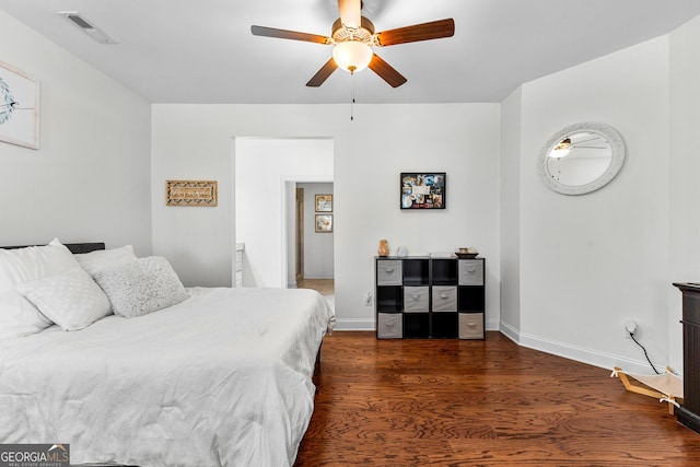 bedroom featuring a ceiling fan, baseboards, visible vents, and wood finished floors