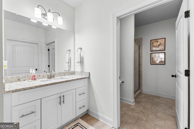 full bath with a shower stall, baseboards, and vanity