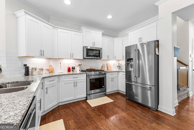 kitchen with appliances with stainless steel finishes, white cabinetry, and dark wood-style floors