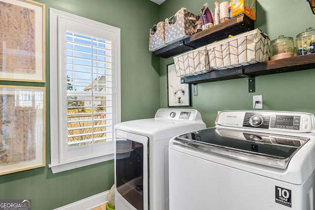 washroom with laundry area, washer and clothes dryer, and baseboards