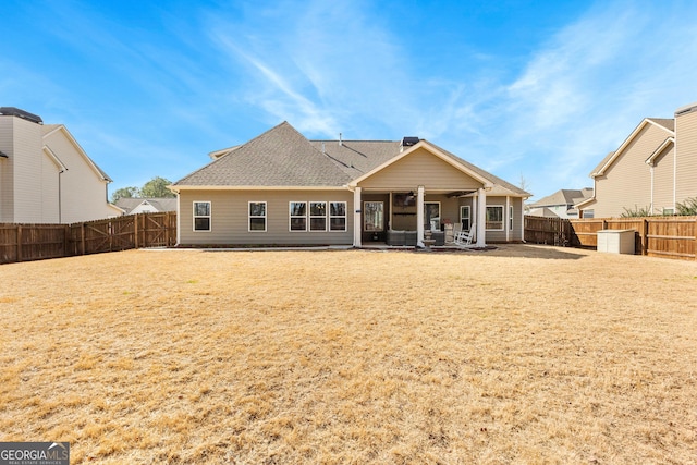 rear view of property with a patio, a shingled roof, a lawn, and a fenced backyard