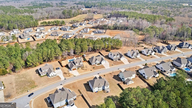 drone / aerial view featuring a residential view and a view of trees