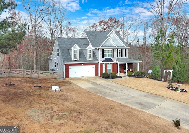 view of front of house featuring a garage, a shingled roof, fence, concrete driveway, and a front yard