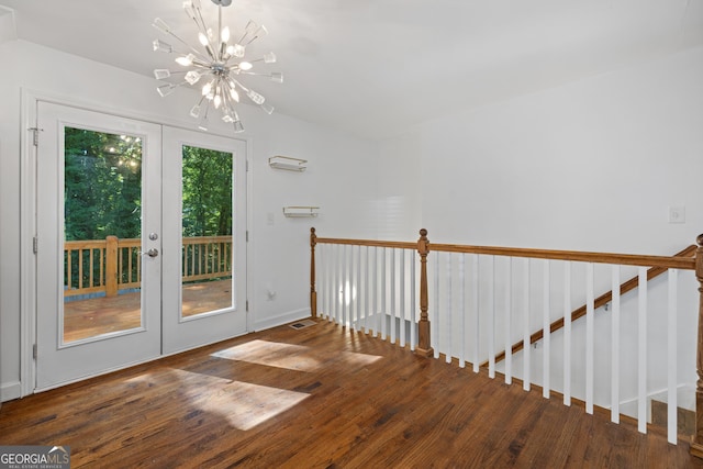 interior space with french doors, wood finished floors, visible vents, and a notable chandelier