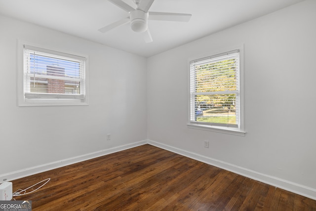 empty room featuring a ceiling fan, dark wood finished floors, and baseboards