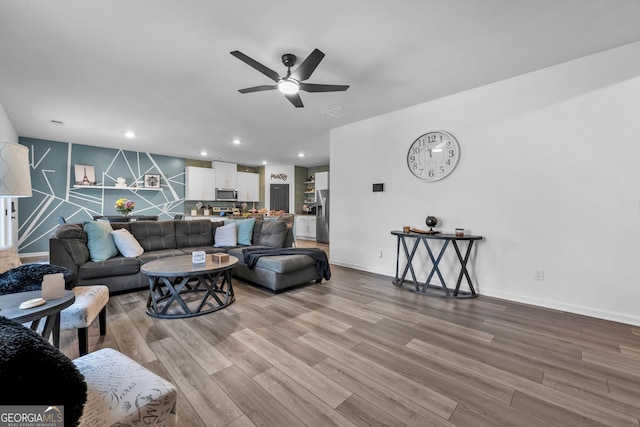 living area with baseboards, a ceiling fan, wood finished floors, and recessed lighting