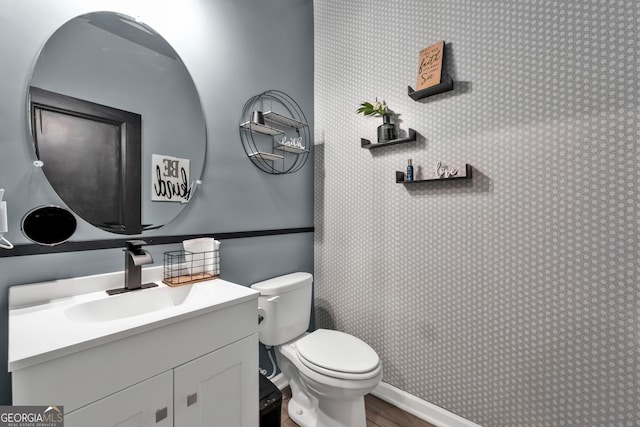 bathroom with wood finished floors, vanity, and toilet