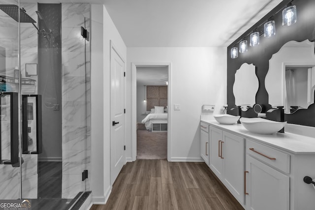 ensuite bathroom featuring a marble finish shower, a sink, ensuite bath, and wood finished floors