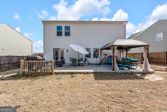 back of property featuring a patio area, a fenced backyard, and a gazebo