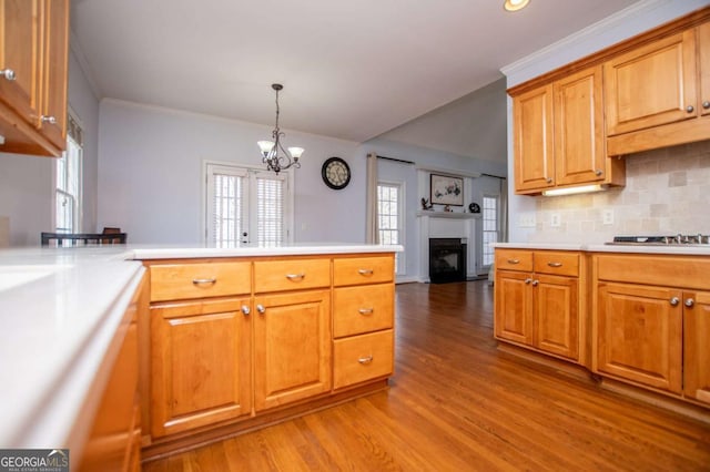 kitchen featuring cooktop, light countertops, a peninsula, and light wood finished floors