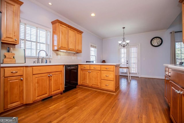 kitchen with a sink, a peninsula, light countertops, and dishwasher