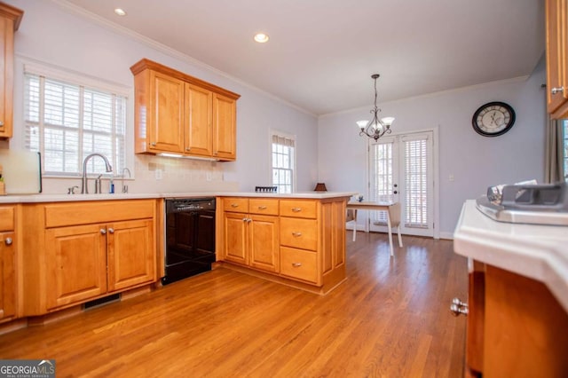 kitchen with a peninsula, a sink, visible vents, dishwasher, and light wood finished floors