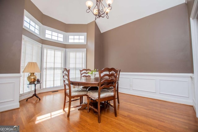 dining room with visible vents, wainscoting, a notable chandelier, and light wood-style flooring