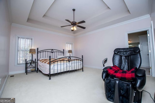 bedroom with multiple windows, a raised ceiling, and carpet flooring