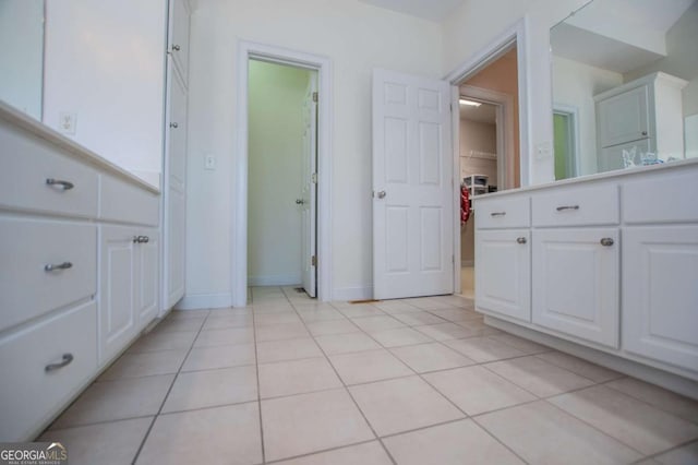 bathroom with tile patterned flooring, a closet, and baseboards