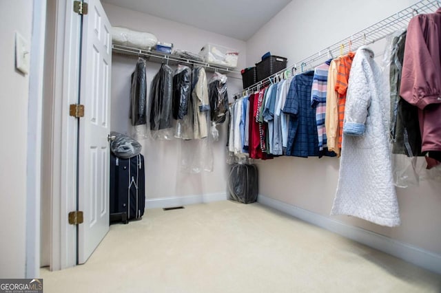 walk in closet with carpet flooring