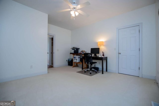 carpeted office featuring a ceiling fan and baseboards