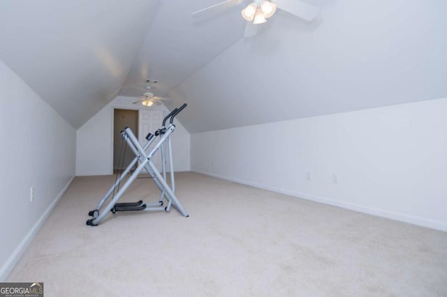 workout area featuring a ceiling fan, baseboards, vaulted ceiling, and carpet flooring