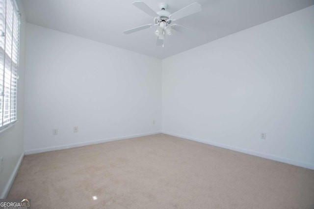 spare room featuring carpet, baseboards, and a ceiling fan