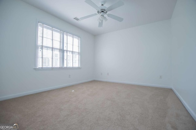 unfurnished room featuring light colored carpet, ceiling fan, visible vents, and baseboards