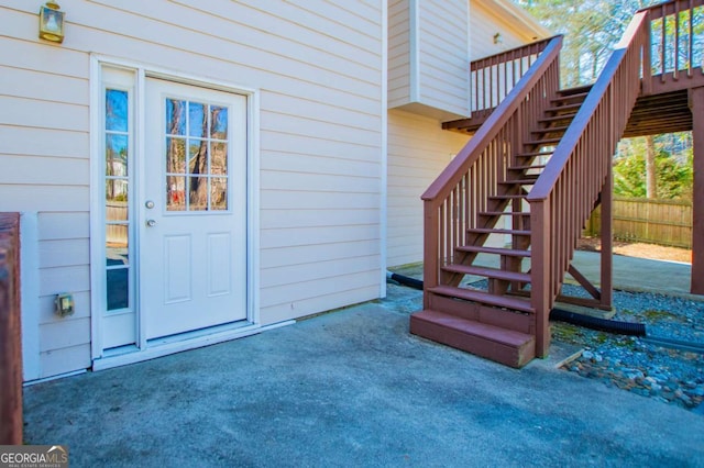 view of exterior entry with fence and a wooden deck