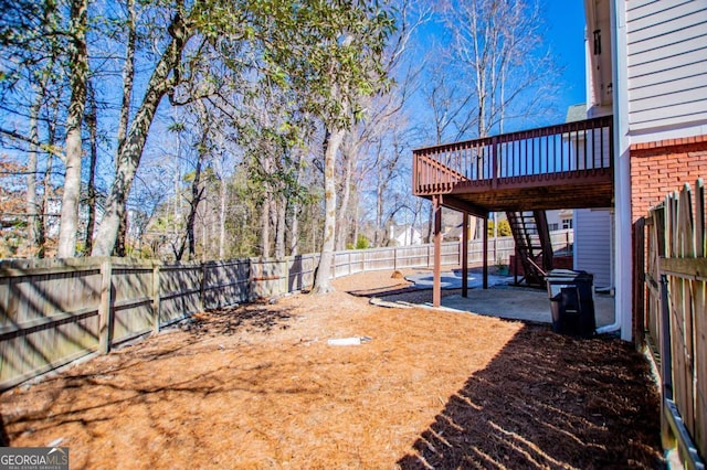 view of yard featuring a fenced backyard, stairs, a deck, and a patio