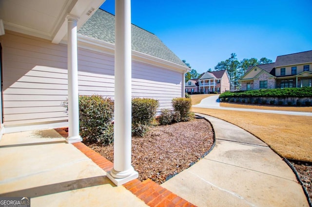 exterior space with a shingled roof and a residential view