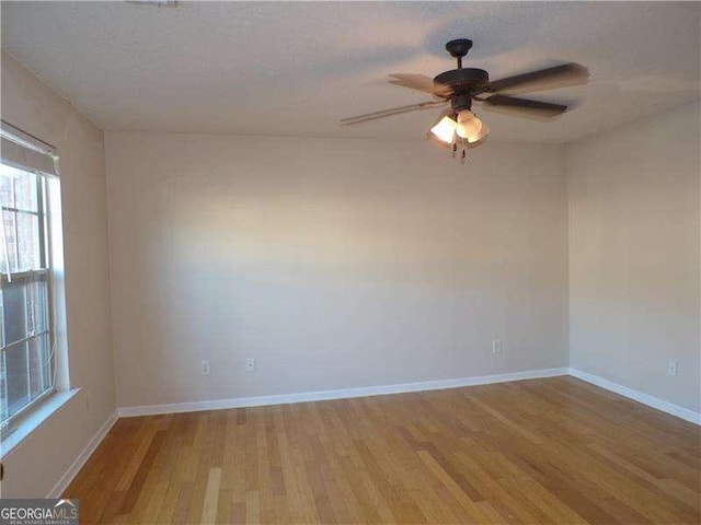 unfurnished room with a ceiling fan, baseboards, and wood finished floors