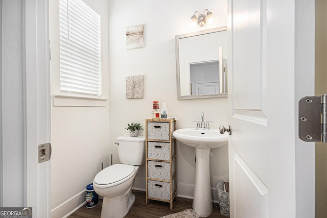 bathroom with baseboards, toilet, and wood finished floors