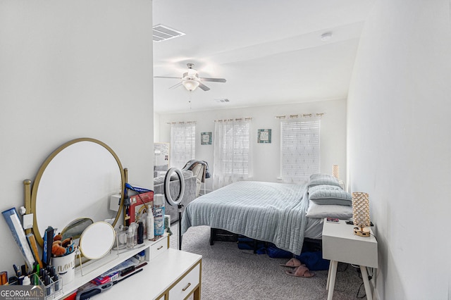 carpeted bedroom featuring ceiling fan and visible vents