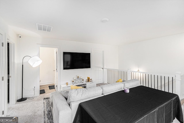 living area with carpet flooring, visible vents, and baseboards