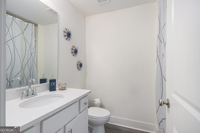 full bathroom featuring baseboards, visible vents, toilet, wood finished floors, and vanity