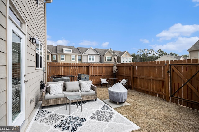 view of patio / terrace featuring a fenced backyard, a gate, a residential view, and an outdoor living space