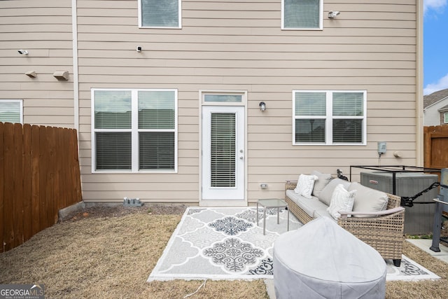 back of house featuring central AC, a fenced backyard, and an outdoor living space