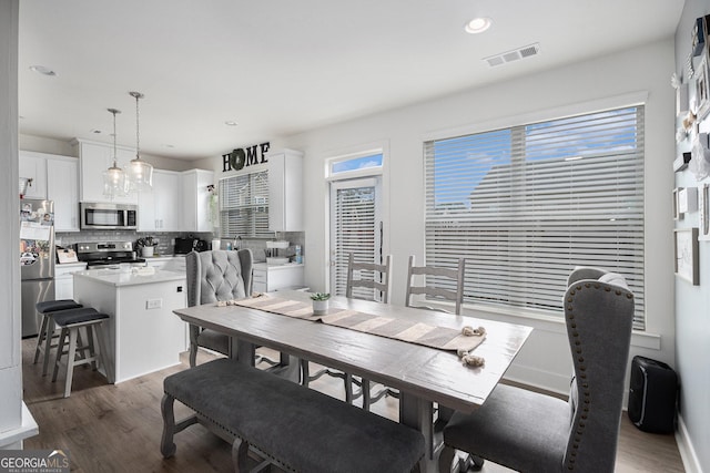 dining space featuring baseboards, light wood-style flooring, visible vents, and recessed lighting