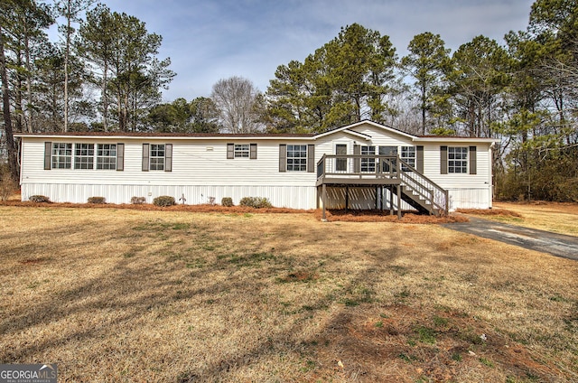 manufactured / mobile home featuring a front yard, a deck, and stairs