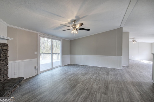 unfurnished living room with a textured ceiling, crown molding, a ceiling fan, and wood finished floors