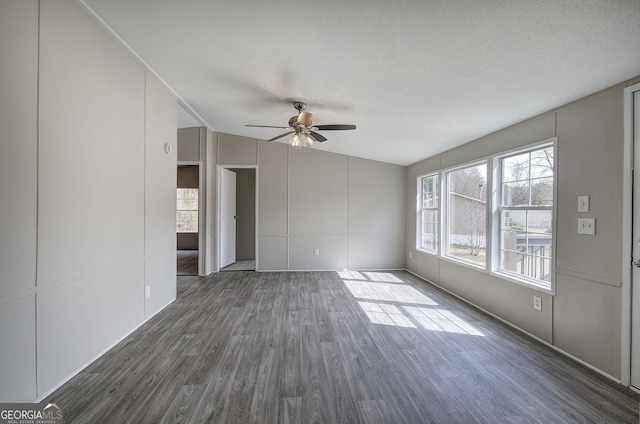 interior space with dark wood finished floors, ceiling fan, a textured ceiling, and lofted ceiling