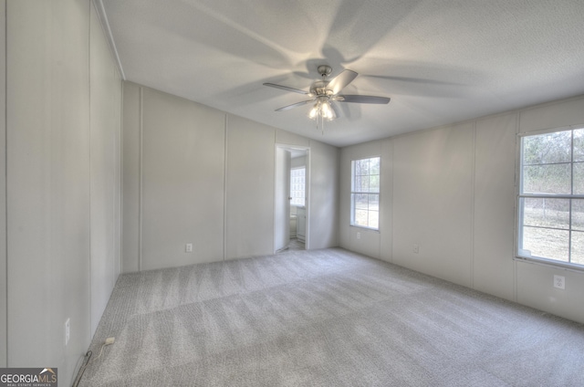 carpeted spare room with a textured ceiling and a ceiling fan