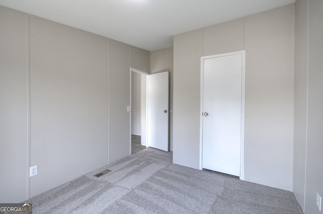 unfurnished bedroom featuring visible vents and carpet