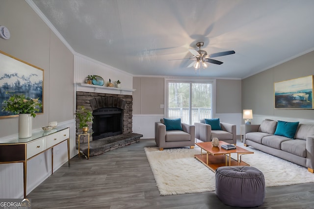 living room with ceiling fan, dark wood-style flooring, a fireplace, and crown molding