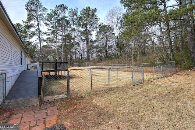 view of yard with a deck, a gate, and fence