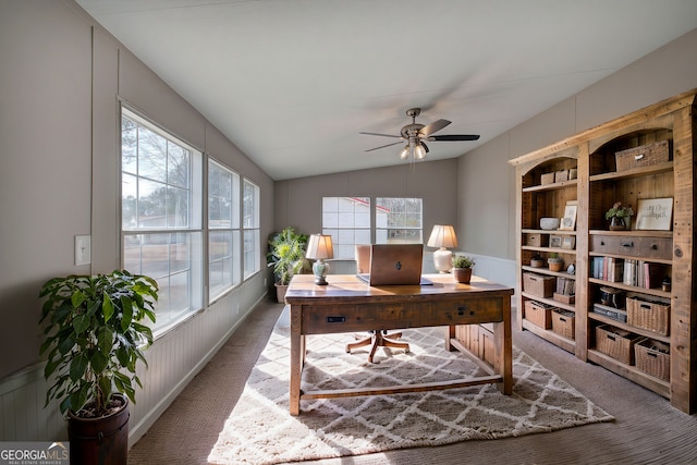 carpeted office space with ceiling fan and lofted ceiling