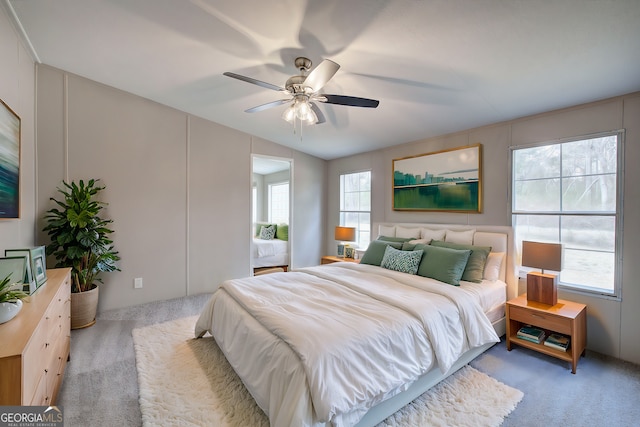 bedroom with multiple windows, light colored carpet, and ceiling fan