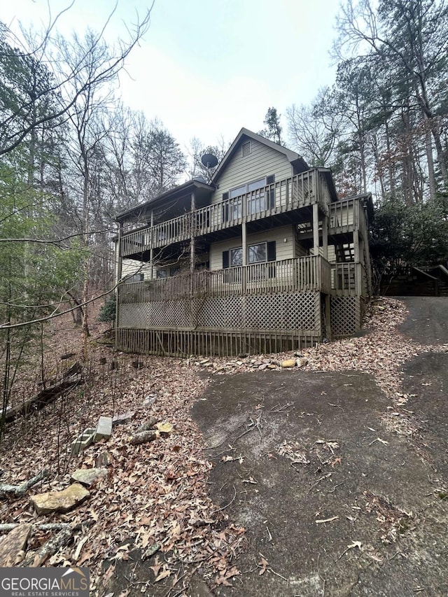 back of house featuring a wooden deck and stairs