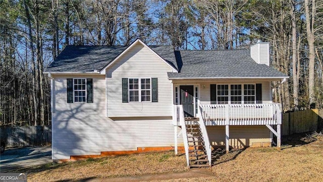 view of front of property with roof with shingles, fence, a chimney, and stairs