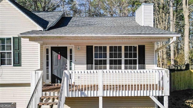 view of front of house featuring a shingled roof and a chimney